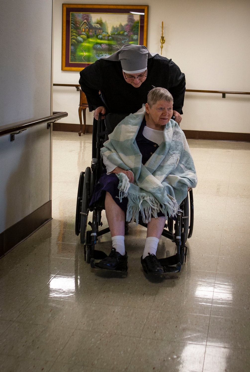 Sister Constance Veit, a Little Sister of the Poor, talks to an elderly resident of the Jeanne Jugan Residence for senior care in Washington while pushing her wheelchair March 25, 2019. Sister Constance is considered a spiritual mother by many of the residents, who said they will honor her on Mother’s Day.